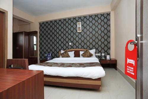 een slaapkamer met een groot bed en een rood bord bij Collection O Hotel Greenpark in Jamshedpur