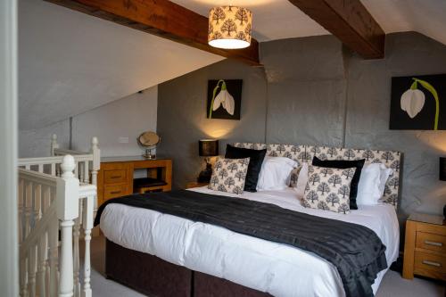 ein Schlafzimmer mit einem großen Bett und einer Treppe in der Unterkunft Gill Cottage, Castle Carrock, Nr Carlisle in Castle Carrock
