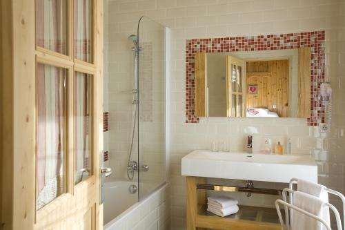 a bathroom with a sink and a shower and a mirror at Hôtel L'Arbina in Tignes