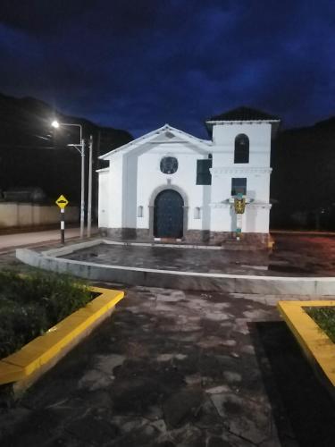 una pequeña iglesia blanca por la noche con luz de la calle en Casa de la Abuela I, en Yucay