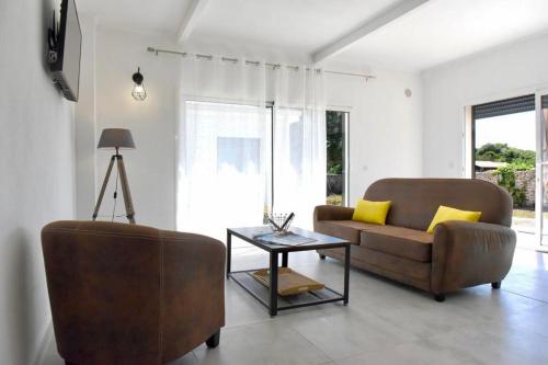 a living room with a couch and a table at Adorable mini-villa jacuzzi Bonifacio 1 in Bonifacio