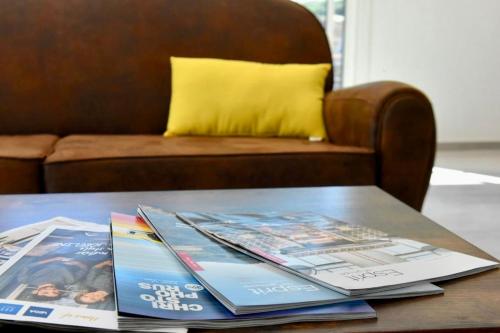 a table with magazines on top of it with a couch at Adorable mini-villa jacuzzi Bonifacio 1 in Bonifacio