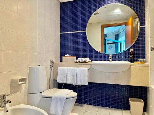 y baño con aseo, lavabo y espejo. en Chic 3 bedroom apartment en Dubái