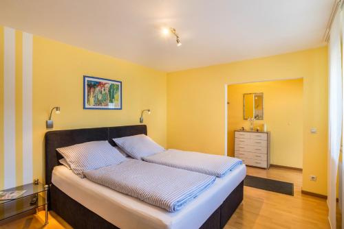um quarto com uma cama grande e paredes amarelas em Ferienwohnung Gernsbach em Gernsbach