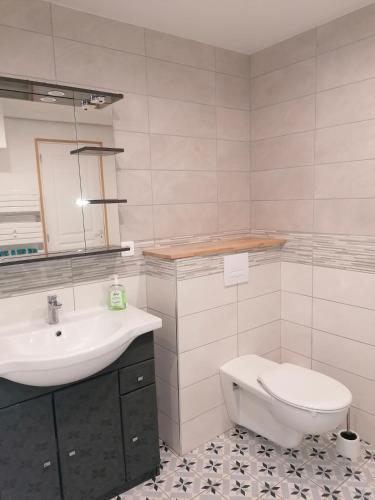 une salle de bain avec un lavabo et des toilettes dans l'établissement La longére fleurie, à Cucq
