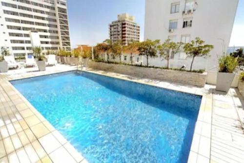 een groot blauw zwembad met gebouwen op de achtergrond bij Lux Tower. Departamento monoambiente. Pleno centro in Punta del Este