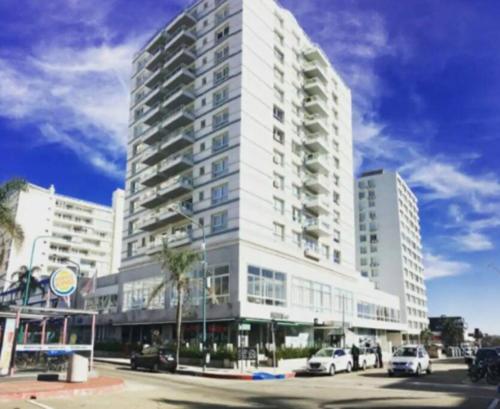 a large white building with cars parked in front of it at Lux Tower. Departamento monoambiente. Pleno centro in Punta del Este