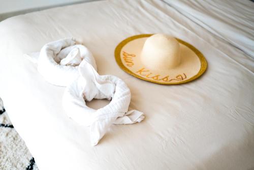 - un chapeau sur un lit avec des sous-vêtements et une serviette dans l'établissement Maison de vacances, VillaNueva, pour 6 personnes à 5min du centre-ville, à Villeneuve-sur-Lot