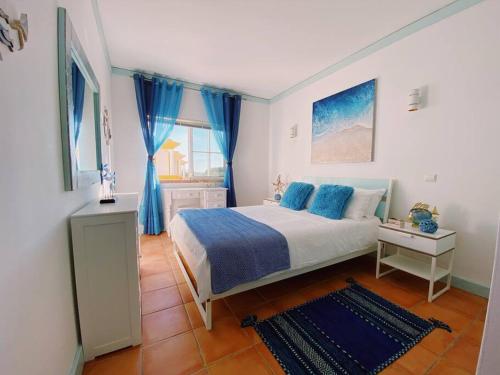 1 dormitorio con 1 cama grande con almohadas azules en Beach House Casa Dolce in Benagil, en Benagil