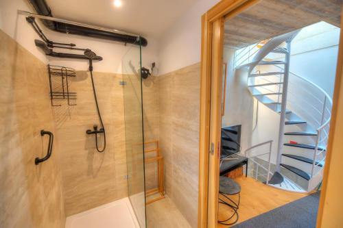 a bathroom with a shower and a spiral staircase at Independent Old House in Gozo With Modernized Interior in Munxar