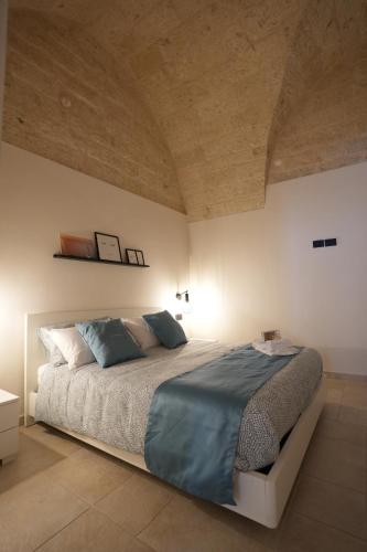 a bedroom with a large bed with blue pillows at La Casetta in Mola di Bari