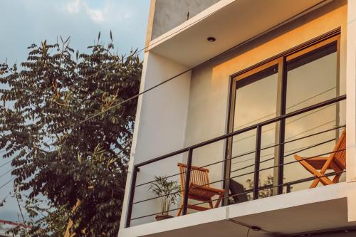 Un balcón de una casa con dos sillas. en Lahos Apartament's, en Panajachel