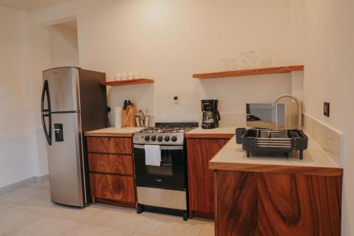 a kitchen with a stove and a refrigerator at Lahos Apartament's in Panajachel