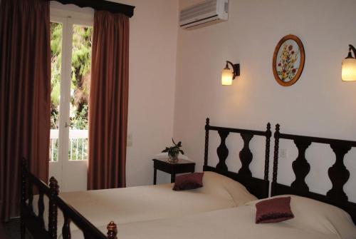 a bedroom with two beds and a window at Pension Alkistis in Tolo