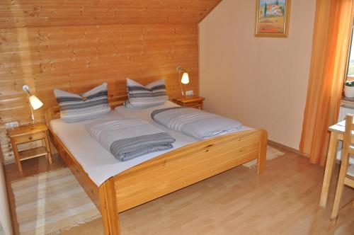 a bed with two pillows on it in a room at Pension Jonas in Baar