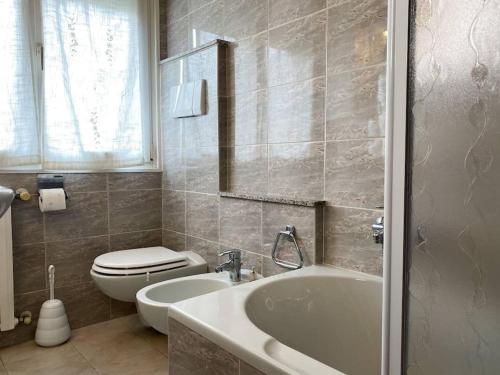 Un baño con bañera, inodoro y lavabo. en Bernina Views-Tirano, en Tirano