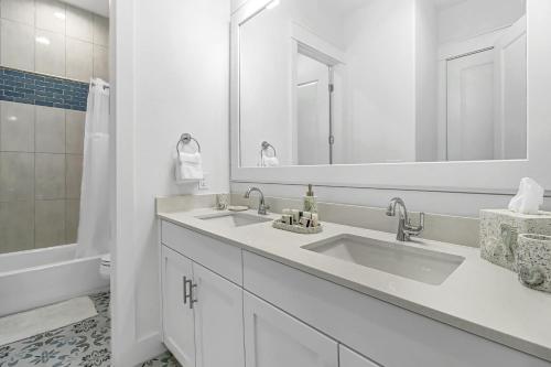 a white bathroom with two sinks and a mirror at The Blue Sails in Port Aransas