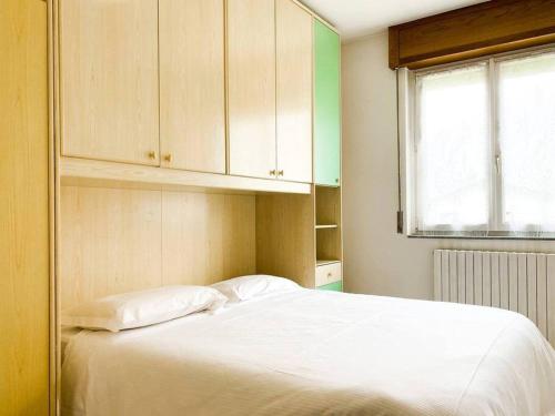 Un dormitorio con una cama blanca y una ventana. en Bernina Views-Tirano, en Tirano