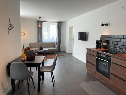 eine Küche und ein Wohnzimmer mit einem Tisch und einem Sofa in der Unterkunft Ferienwohnung-Domziegelhof in Schleswig