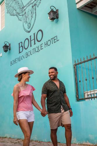 a man and woman standing in front of a blue building at BOHO Bohemian Boutique Hotel in Willemstad