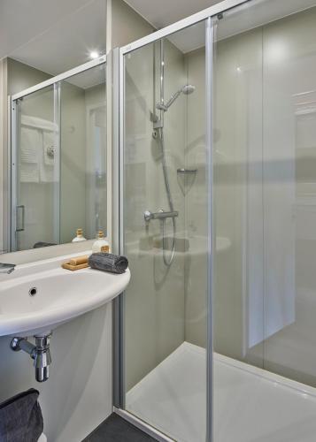 a bathroom with a shower and a sink at Holiday Suites Jabbeke - Klein Strand in Jabbeke