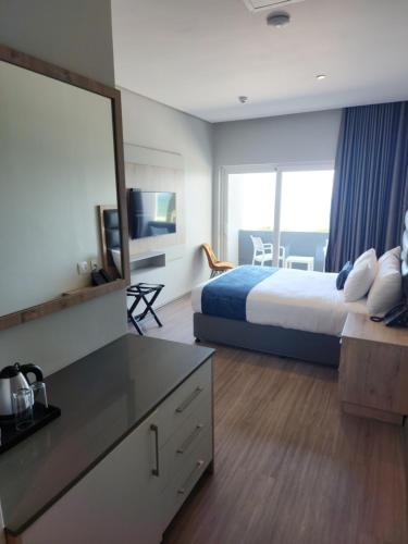 Habitación de hotel con cama y espejo grande en 12 Oceans Hotel and Conference Centre, en Kingsborough