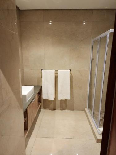 - Baño con lavamanos y 2 toallas en 12 Oceans Hotel and Conference Centre, en Kingsborough
