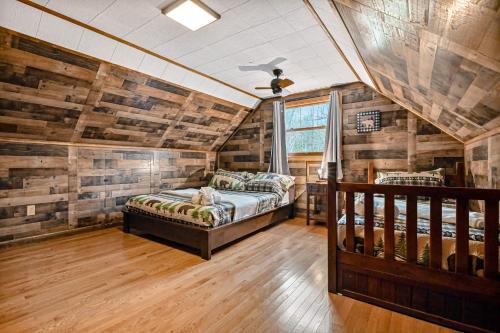 a bedroom with two beds in a room with wooden walls at Woodland Cabin Retreat in Lake Harmony