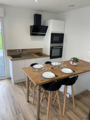 - une cuisine avec une table en bois et des verres à vin dans l'établissement Escapade Normande avec son sauna privé, à Le Tourneur
