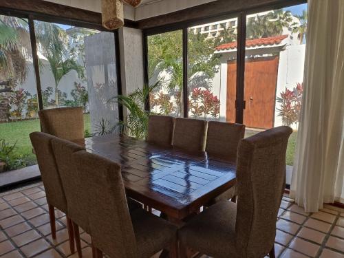 a dining room with a wooden table and chairs at Cancun Villa Agave, access to the Beach! in Cancún