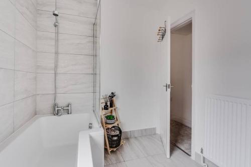 a white bathroom with a tub and a shower at Liverpool 3 bed house (free parking) in Liverpool