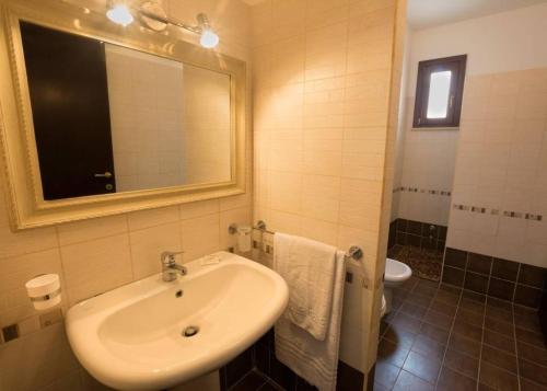 uma casa de banho com um lavatório, um espelho e um WC. em VILLA DAIANA em Lampedusa