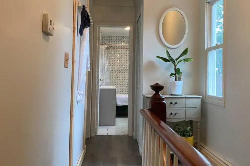 a hallway with a bathroom with a sink and a mirror at Studio Apt w Garden in Kingston