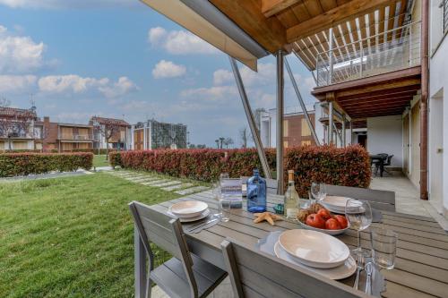 un tavolo in legno con un cesto di frutta su un patio di Borgo Gasparina Family Apartments a Castelnuovo del Garda