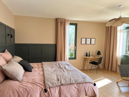 a bedroom with a bed and a desk in a room at LA DEMEURE in Précy-sur-Oise