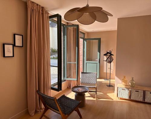 a living room with two chairs and a large window at LA DEMEURE in Précy-sur-Oise