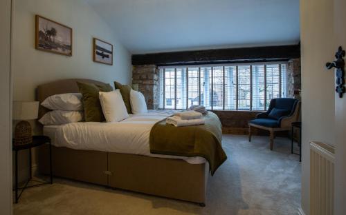 sypialnia z dużym łóżkiem i niebieskim krzesłem w obiekcie The Potting Shed w mieście Chepstow