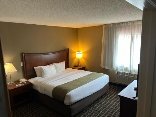 a hotel room with a large bed and a window at Quality Inn & Suites Bradford in Bradford