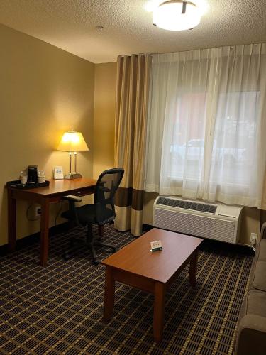 a hotel room with a desk and a window at Quality Inn & Suites in Bradford