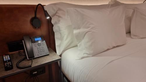 a hotel room with a phone on a bed at Hotel Principe Avila in Lisbon