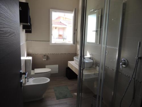 a bathroom with a sink and a toilet and a window at Il Colle del Barone in Capoterra