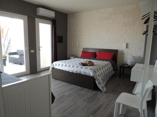 a bedroom with a bed with red pillows at Il Colle del Barone in Capoterra