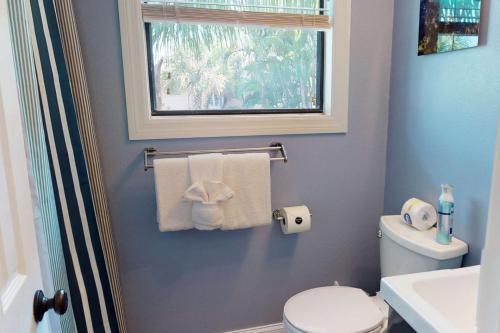 a bathroom with a white toilet and a window at 805 - Friendly Native Beach Resort in St. Pete Beach
