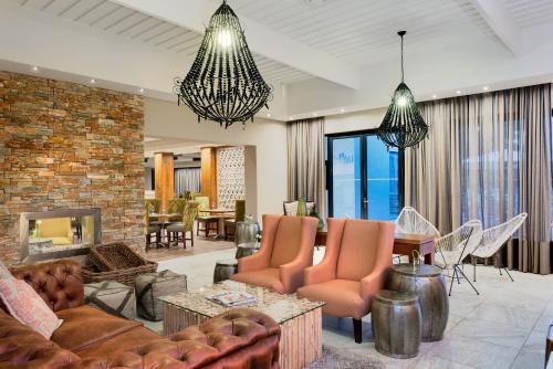 a living room with a couch and chairs and a fireplace at ANEW Resort Hunters Rest Rustenburg in Rustenburg
