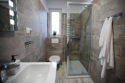 La salle de bains est pourvue d'une douche, de toilettes et d'un lavabo. dans l'établissement Słoneczna Sielanka domki w Bieszczadach, à Ustrzyki Dolne