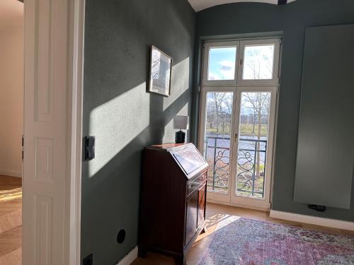 a room with a tv and a window and a door at Villa Schuwardt auf Nordend in Rathenow