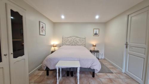 a bedroom with a bed and a table in it at Gîte de la Noyelle à Sainghin en Mélantois in Sainghin-en-Mélantois