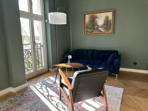 a living room with a blue couch and a table at Villa Schuwardt auf Nordend in Rathenow