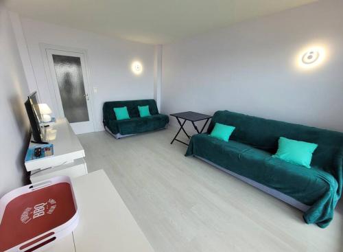勒克魯西克的住宿－Panorama & Côte sauvage - Studio - Les Gîtes de la Côte d'Amour，客厅配有绿色沙发和桌子