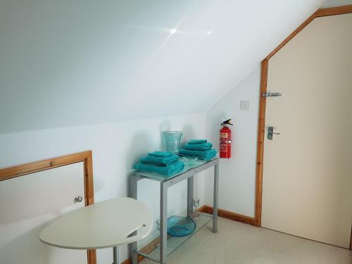 a room with a table and a fire extinguisher at Meadow Oak Accommodation in Bodmin